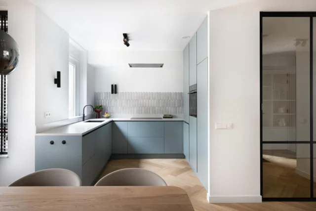 🍽️ Fris, tijdloos en tot in detail doordacht

Deze keuken is het perfecte voorbeeld van hoe kleur, vorm en materiaalkeuze samenkomen in een rustige maar karaktervolle ruimte.

De zachte blauwgroene fronten zorgen voor een subtiele kleurinjectie, zonder schreeuwerig te worden. In combinatie met het neutrale werkblad, de visgraatvloer en de glanzende wandtegels in visvorm ontstaat er een verfijnd geheel dat naadloos aansluit bij de rest van het interieur.

➕ Veel werkruimte zonder in te leveren op licht
➕ Een slimme indeling voor dagelijks comfort
➕ Verticale wandlampen en wandtegels voor extra ritme en sfeer

Deze keuken vormt niet alleen een praktische plek om te koken, maar ook een stijlvolle verbinding met de eetkamer en zithoek. Een rustige basis met nét dat beetje lef.